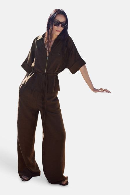Bruine wijde broek van MANGO, gestyled als onderdeel van een matchende jumpsuit met sandalen.