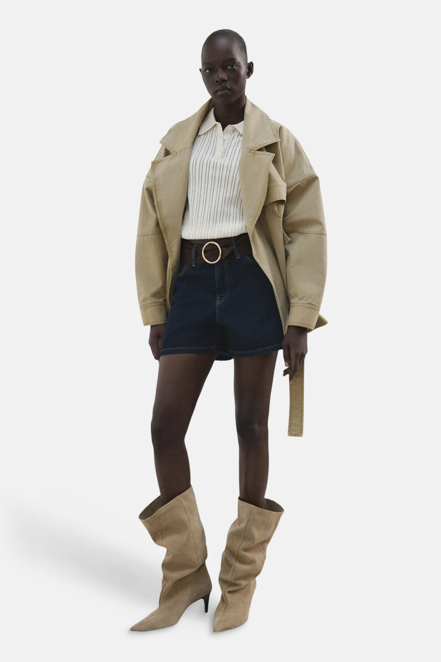 Short en jean bleu marine de MANGO, avec une ceinture marron et une grande boucle ronde, combiné avec des bottes.