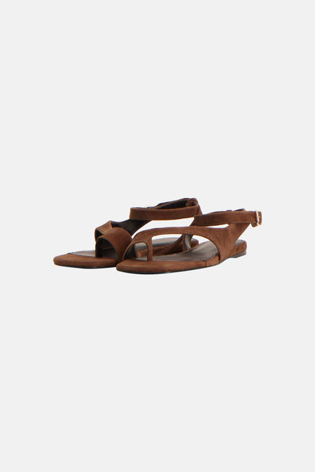 Bruine suède-look sandalen van MANGO met platte zool, enkelbandje en goudkleurige gesp, liggend.