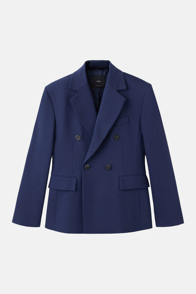 Blazer oversize bleu de MANGO, porté sur un haut noir et une jupe asymétrique à imprimé Union Jack.