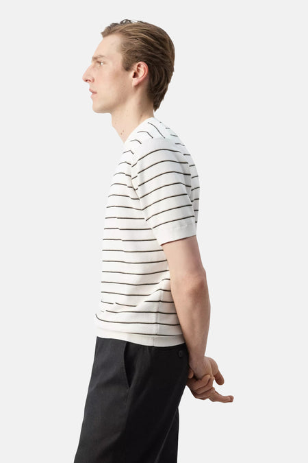 Wit T-shirt met fijne horizontale zwarte en beige strepen van MANGO, gedragen in zijprofiel.