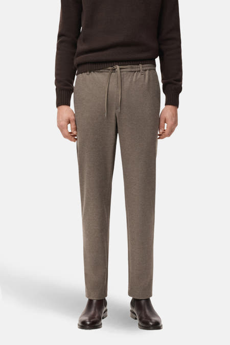 Bruine broek van MANGO met trekkoord en een gladde textuur, gecombineerd met een bruine trui en donkere schoenen.
