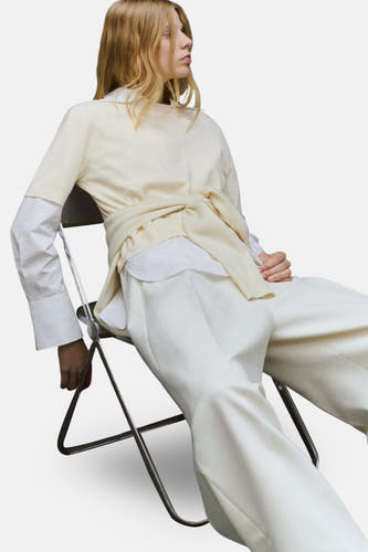 Veste écru avec col rond de MANGO, nouée à la taille et associée à un pantalon blanc.