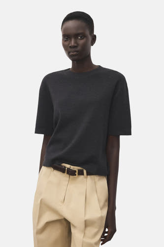 Grijs trui met ronde hals van MANGO, gecombineerd met beige pantalon en een bruine riem.
