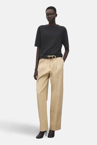 Grijze trui met ronde hals van MANGO, gedragen met beige pantalon met riem en donkere schoenen.

