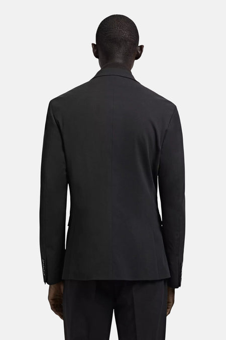 Zwarte blazer van MANGO, getoond van achteren op een mannelijk model met een coltrui en een bijpassende broek.
