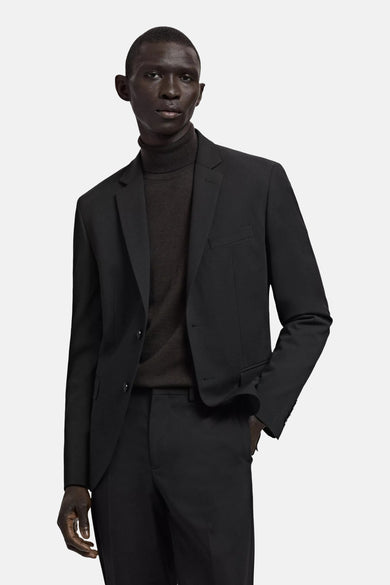 Blazer noire de MANGO, vue de dos sur un mannequin masculin portant un col roulé et un pantalon assorti.
