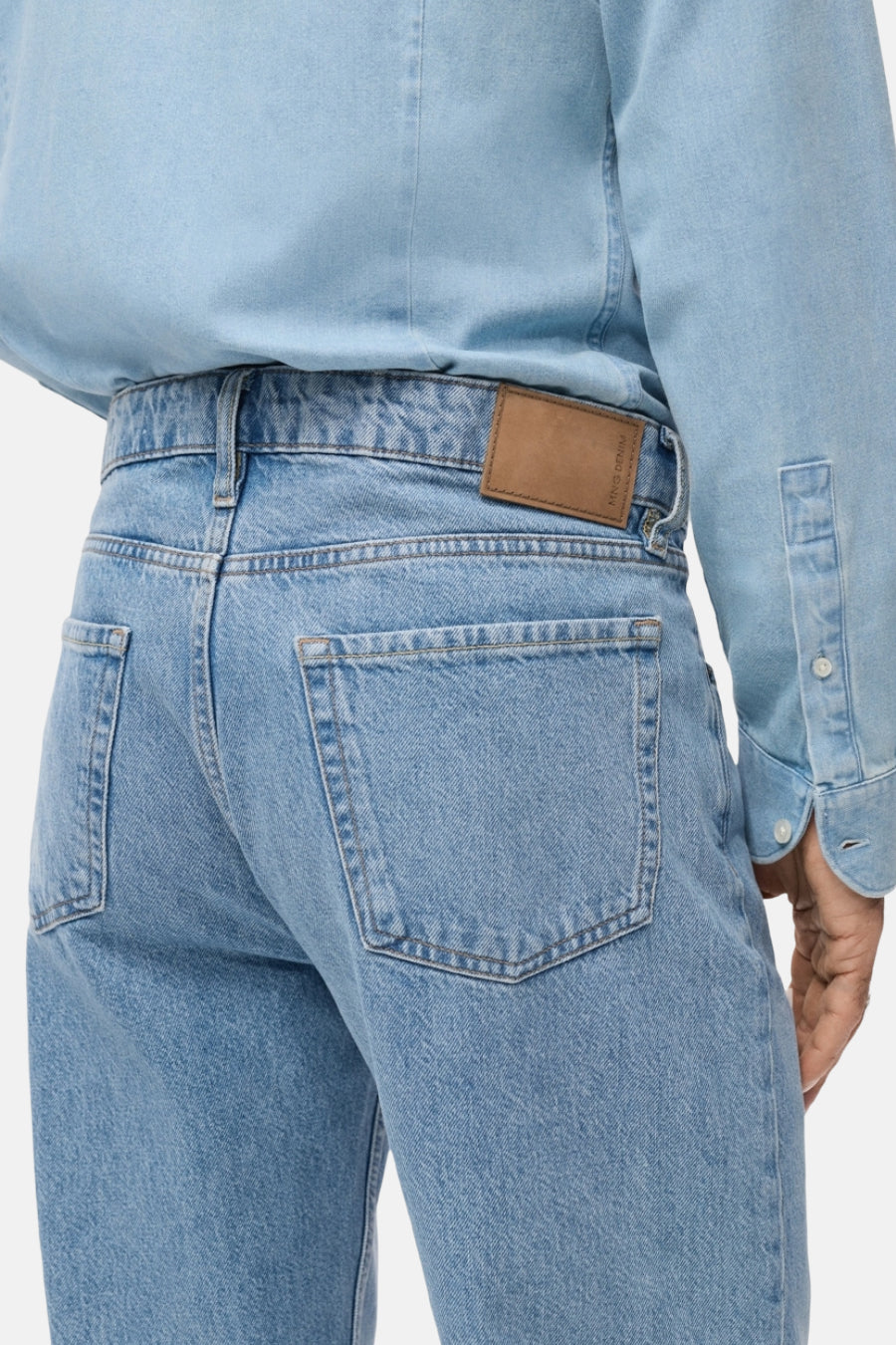 Lichtblauwe straight jeans van MANGO, met bruin leren merklabel en achterzakken.