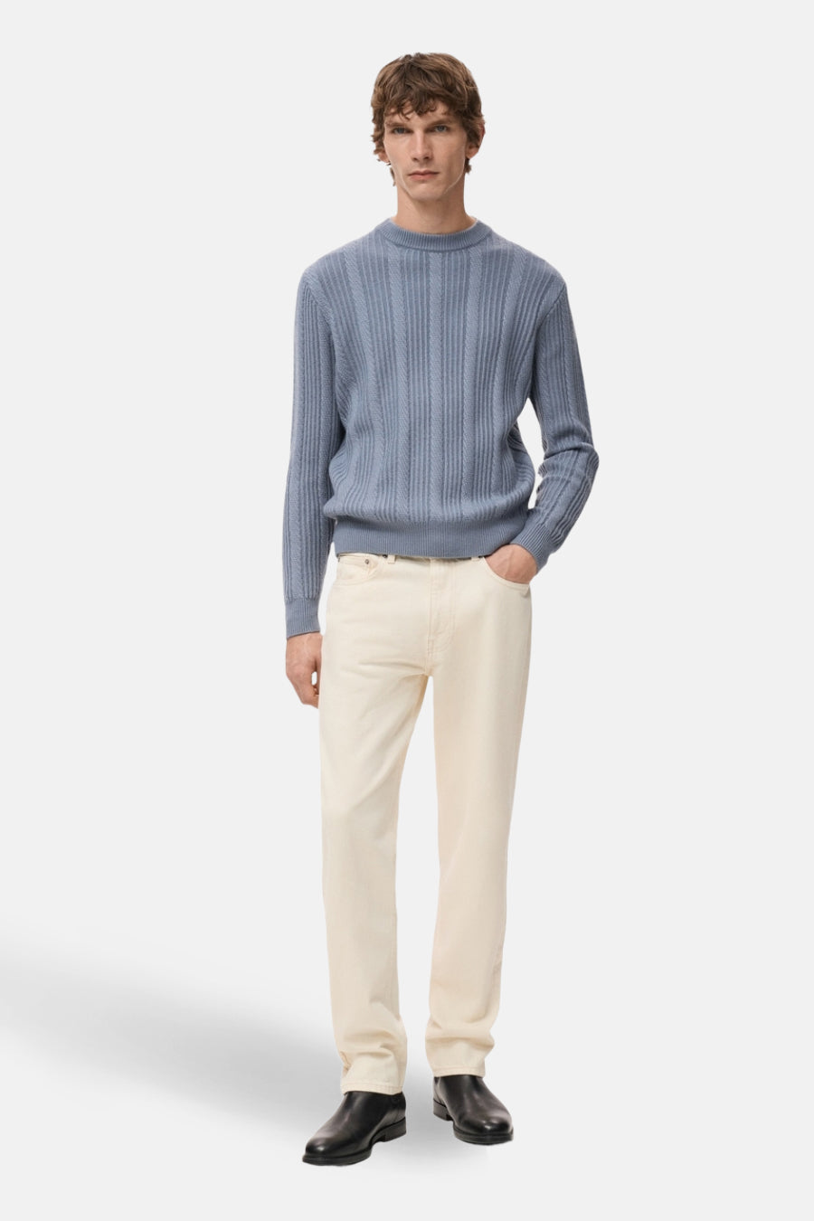T-shirt bleu avec col rond de MANGO, à un motif côtelé vertical, porté avec des pantalons beige et des chaussures noires.