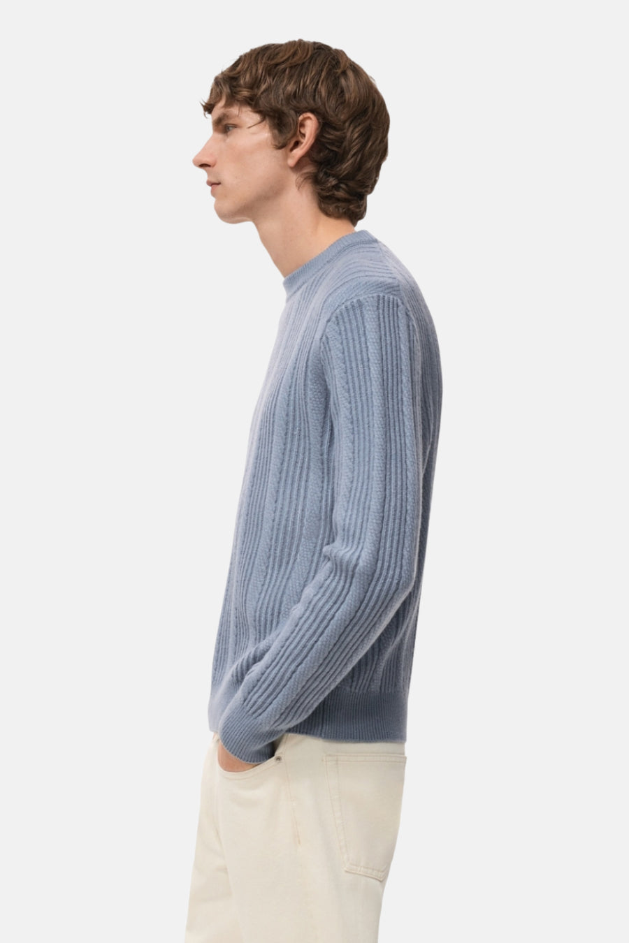 T-shirt bleu avec col rond de MANGO, à rayures horizontales, porté avec un pantalon beige, en vue latérale.
