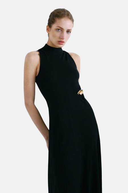 Robe sans manches noire de MANGO, avec un haut attaché et une jupe détachable avec un détail doré.