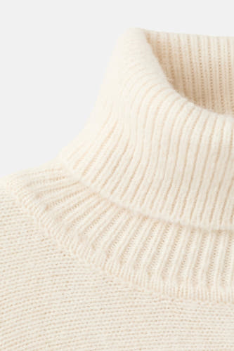 Poncho écru de MANGO, avec une coltrui tricotée et une douce texture.