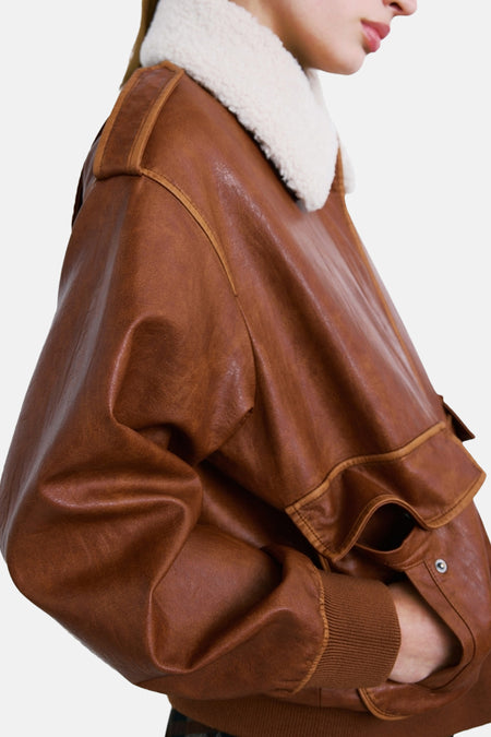 Bruine korte jas van MANGO met een kraag van imitatiebont, ribgebreide boorden en een knoopzak detail, zijaanzicht.
