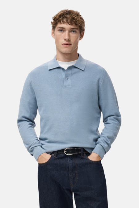 Blauw poloshirt van MANGO, met lange mouwen en gedragen met donkere jeans en een zwarte riem.
