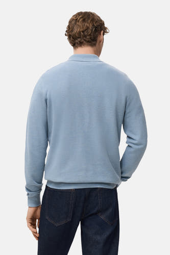 Blauwe trui van MANGO, gezien van achteren, gecombineerd met donkere jeans.
