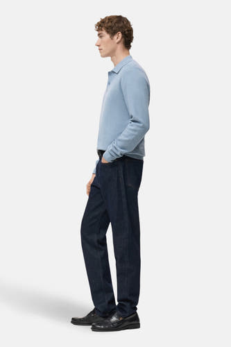 T-shirt bleu de MANGO, avec des manches longues, associé à des jeans foncés et des loafers noirs, en vue latérale.