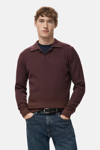 Bordeaux trui met V-hals van MANGO, met lange mouwen en gedragen met een donkerblauwe top en jeans.
