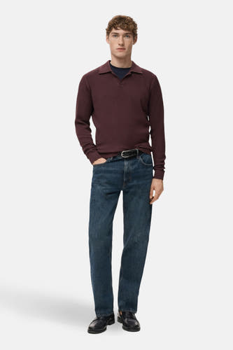 Veste Bordeaux avec col V de MANGO, portée avec un haut bleu marine et des jeans avec une ceinture.