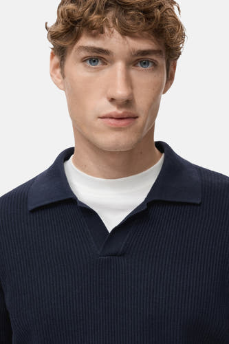 T-shirt bleu à col V de MANGO, avec une texture côtelée, porté sur un T-shirt blanc.