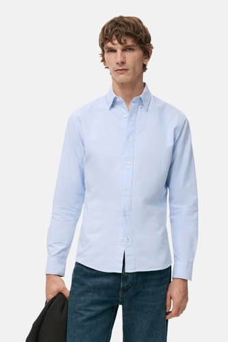 Chemise bleue à manches longues de MANGO, vue de derrière, associée à un jean foncé.