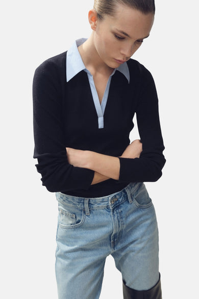 Blauwe trui met V-hals van MANGO, met lange mouwen en gedragen met een lichtblauwe jeans.
