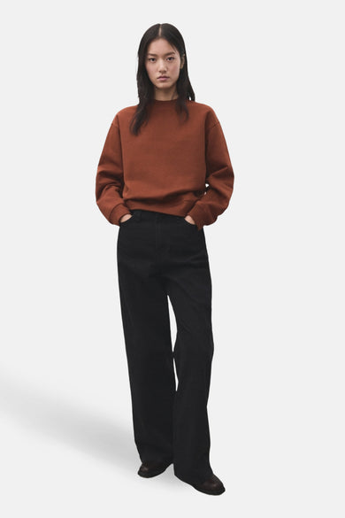 Pull-over marron de MANGO, porté avec un jean noir et des chaussures marrons.