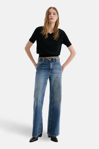 Rechte jeans van midblauw denim van MANGO, gedragen met een zwarte riem en zwarte schoenen.
