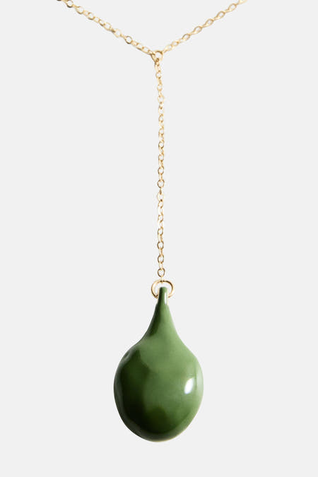 Lange groene halsketting van MANGO, met een gouden ketting en een druppelvormige groene hanger.
