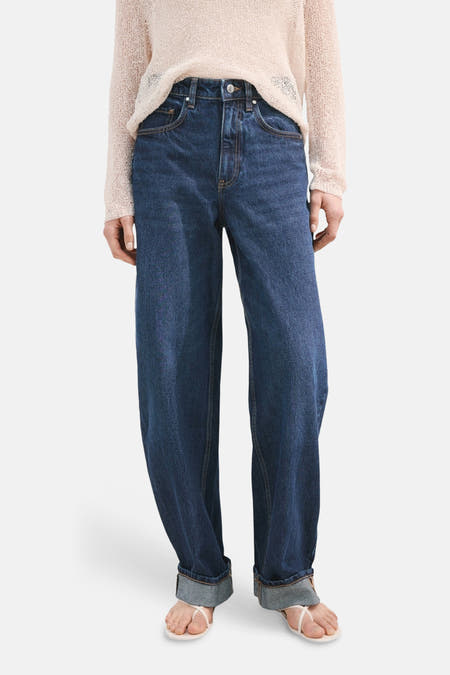 Donkerblauwe denim jeans special fit van MANGO, met opgerolde pijpen en gecombineerd met een los gebreide trui.
