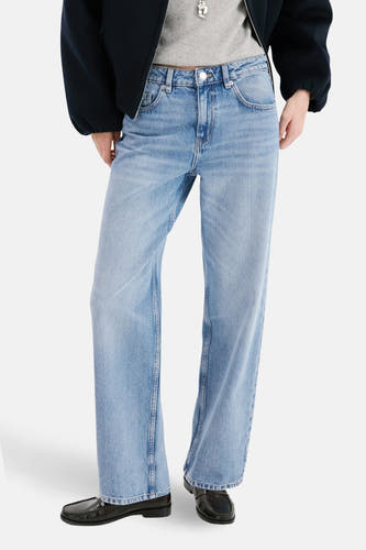 Jean droit bleu clair de MANGO, vu de derrière, associé à un blazer bleu foncé et des chaussures noires.