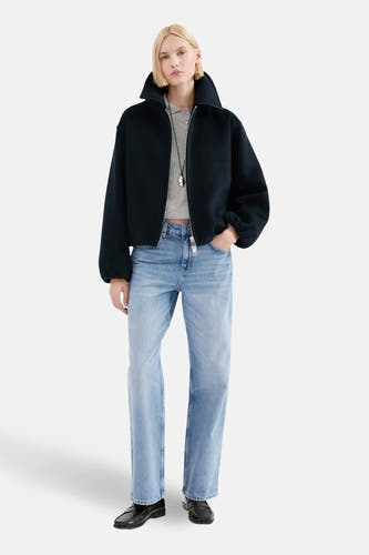 Jean en denim bleu clair MANGO,,é avec un mau et bleu foncé et des loafers noirs.