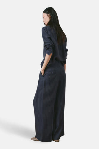 Blauwe broek van MANGO met krijtstreep en wijde pijpen, achterkant gezien.