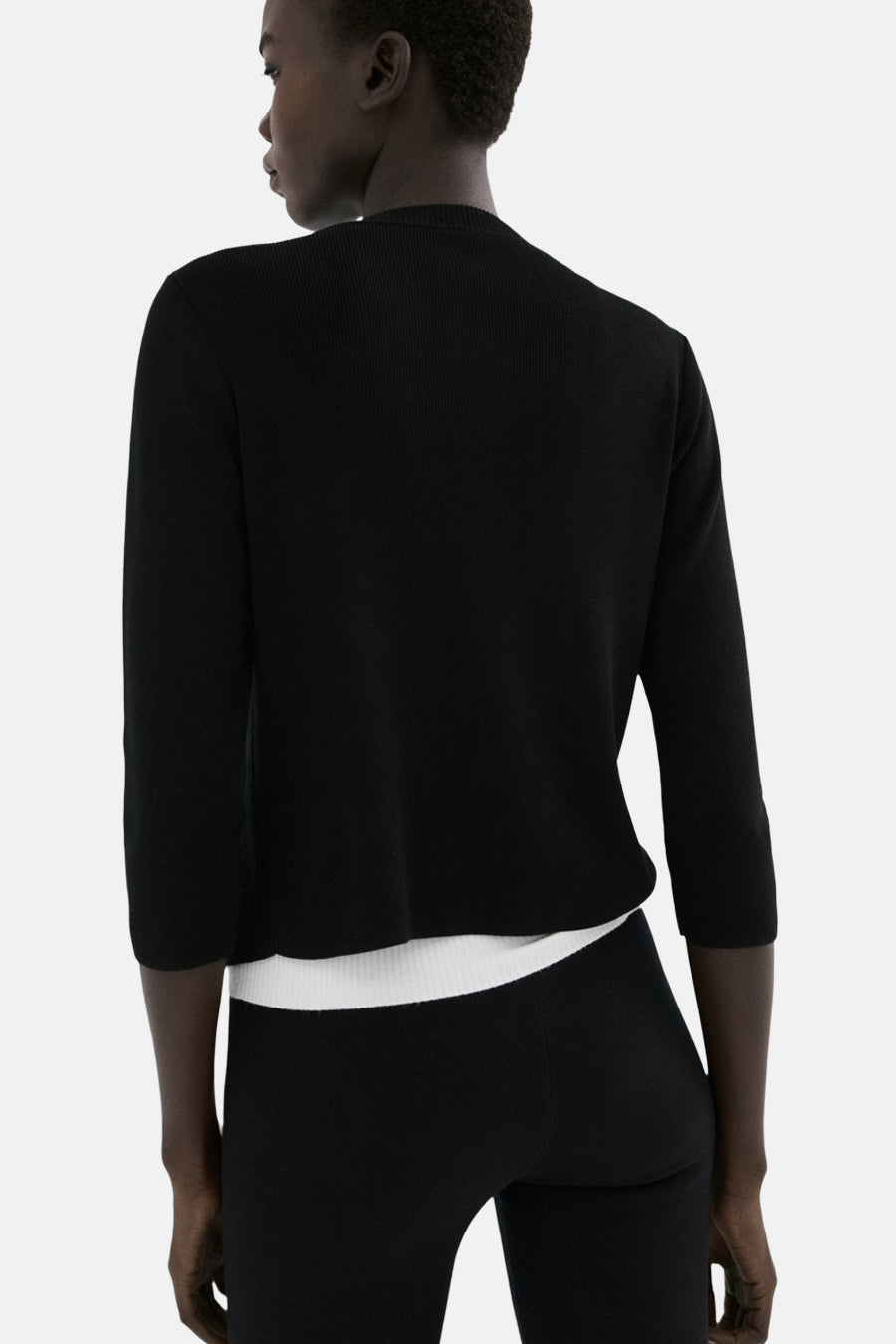Zwart gilet van MANGO, gezien van achteren, met driekwart mouwen en een witte top eronder.