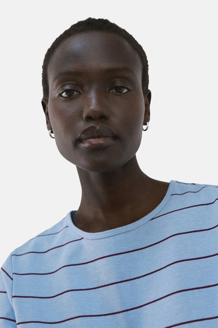 Blauw T-shirt van MANGO, met een horizontaal gestreept patroon in blauw en bordeauxrood.
