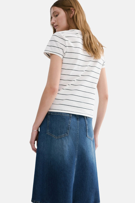 Wit gestreept T-shirt van MANGO, met korte mouwen, gecombineerd met een donkerblauwe denim rok.
