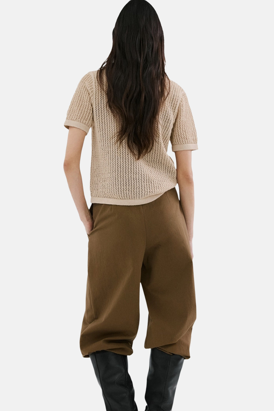 Bruine gilet van MANGO, met textuur en gedragen over een crèmekleurige top en bruine broek, gezien van achteren.
