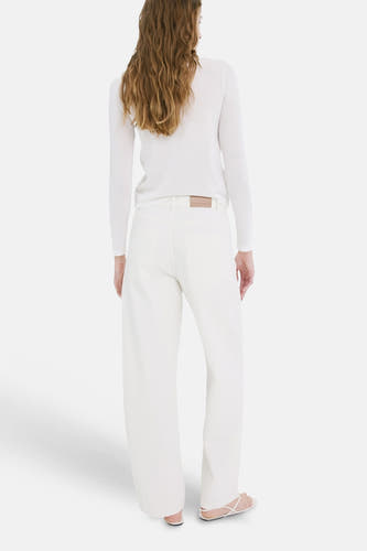Off-white denim wijde jeans van MANGO, van achteren gezien, gedragen met een witte top en sandalen.