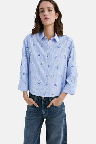 Blauwe lange mouwen blouse met fijne strepen en bloemenprint van MANGO, voorzien van borstzakje en knoopsluiting, gedragen met donkerblauwe jeans.