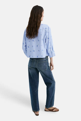 Blauwe blouse met lange mouwen en bloemenprint van MANGO, gedragen met donkerblauwe jeans en bruine sandalen, achterzijde weergegeven