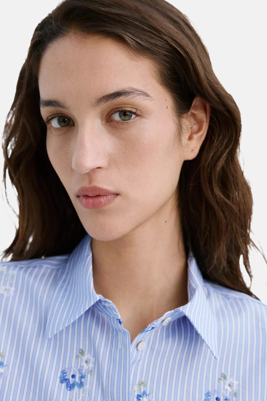 Blauwe lange mouwen blouse met witte strepen en bloemen borduurwerk van MANGO, close-up op model