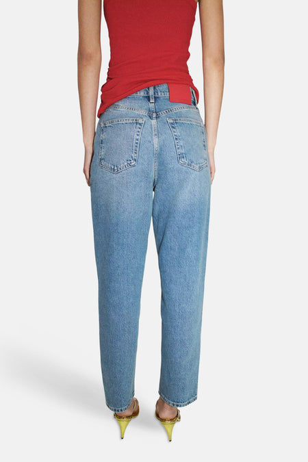 Lichtblauwe mom jeans van MANGO, achterzijde, met klassieke zakken en rechte pasvorm, gedragen met rode top en gouden hakken