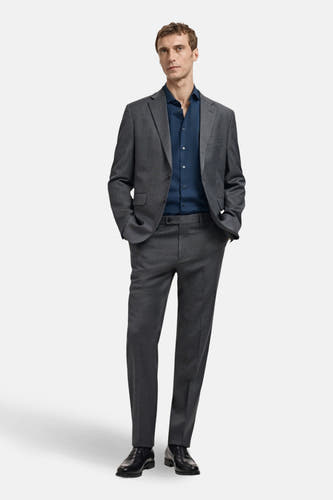 Blauw overhemd met lange mouwen van MANGO, gedragen onder een grijs pak met zwarte schoenen.
