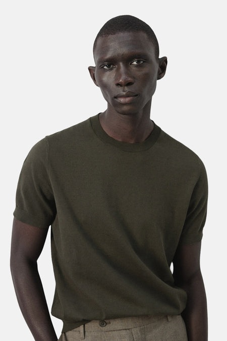 T-shirt à manches courtes de MANGO, uni et porté avec un pantalon à carreaux.