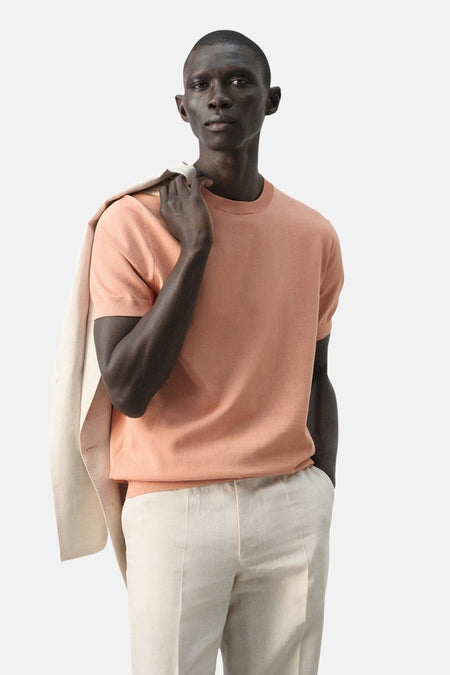 T-shirt à manches courtes orange de MANGO, vu de dos, avec un pantalon en lin beige.