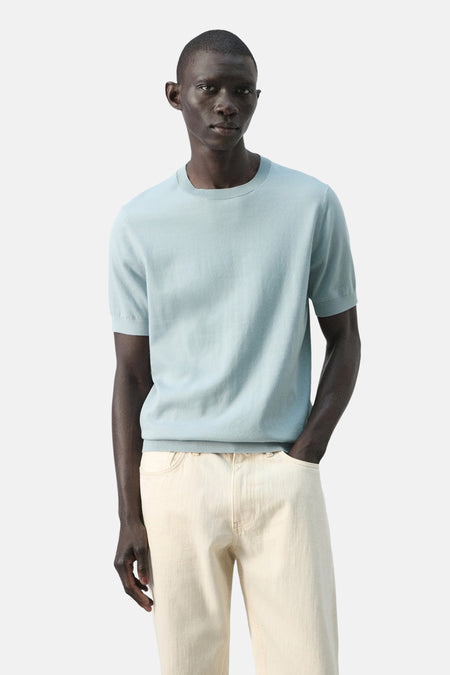 T-shirt bleu à manches courtes de MANGO, vu de dos, combiné avec un pantalon de couleur claire.