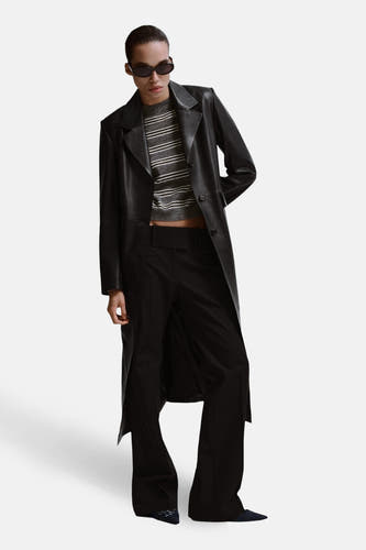 Pull gris à col rond de MANGO, à rayures horizontales, porté sous une veste et un pantalon en cuir noir.