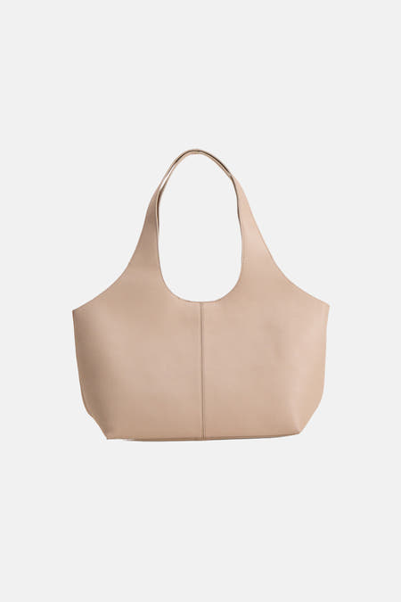 Beige schoudertas van MANGO, met een subtiele korrelstructuur en gladde handvatten.
