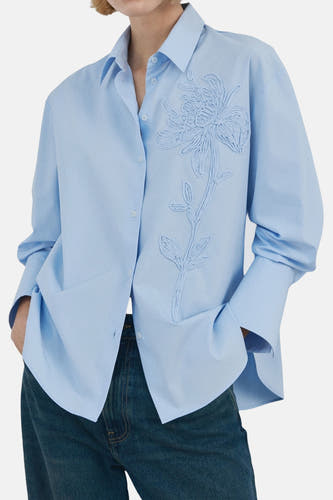 Blauw overhemd met lange mouwen van MANGO, versierd met een delicate bloemapplicatie op de borst.