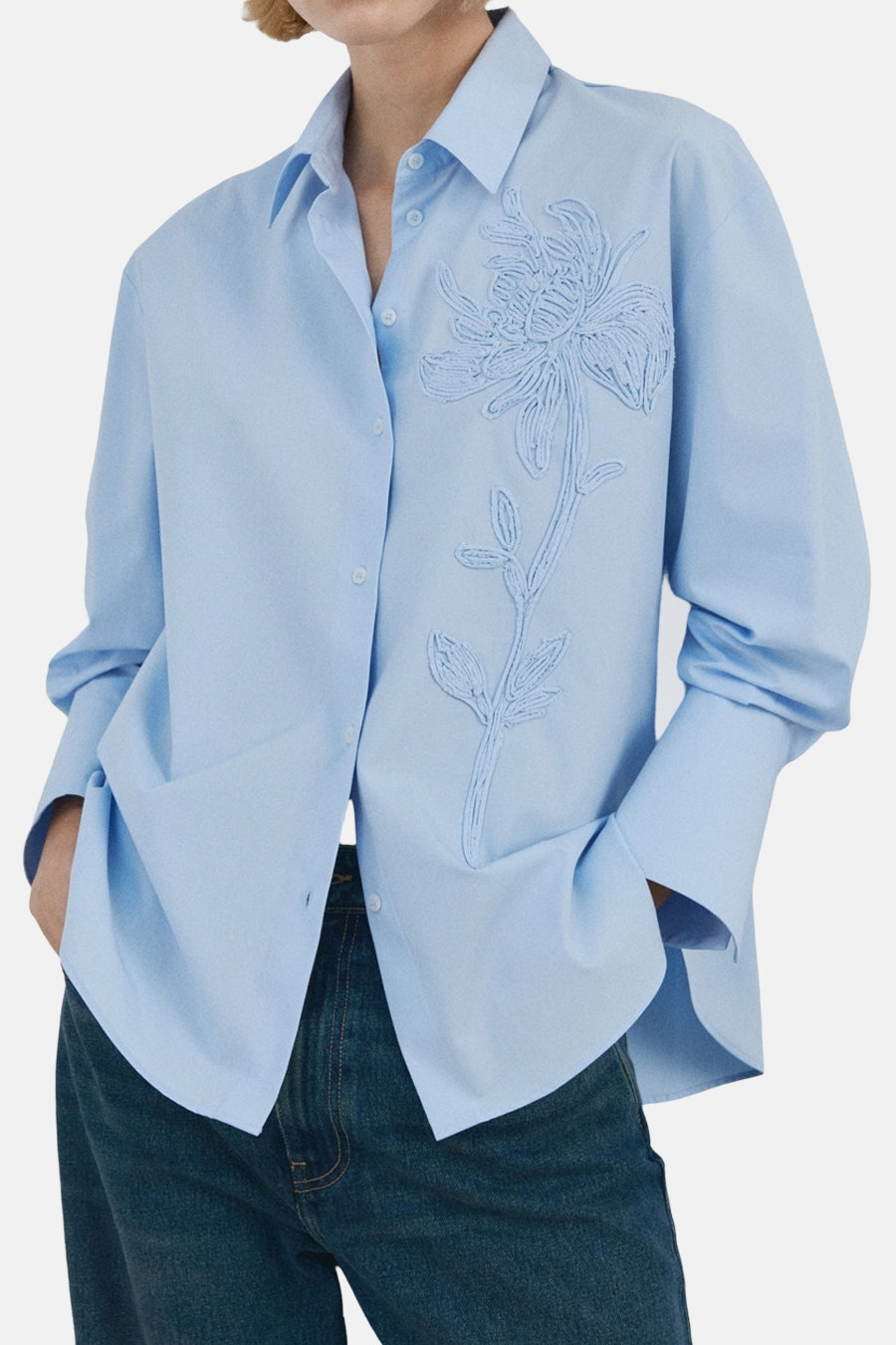 Blauw overhemd met lange mouwen van MANGO, versierd met een delicate bloemapplicatie op de borst.
