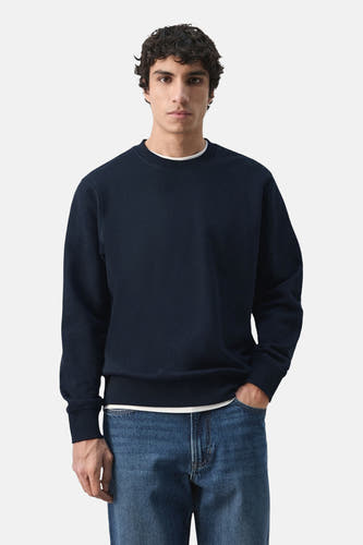 Zwarte sweater van MANGO, gedragen met een wit T-shirt en blauwe jeans.
